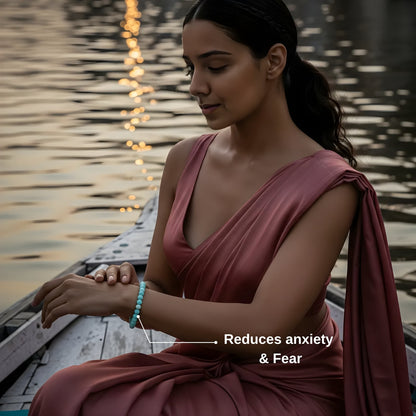 Woman in a pink dress sitting by a waterfront with text 'Reduces anxiety & Fear'.